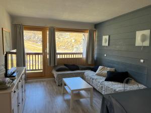 a living room with a couch and a table at L'olympic in Val Thorens