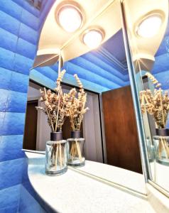 a bathroom with a mirror and three vases with trees at Nice and spacious apartment- Silvio 2 in Banjole
