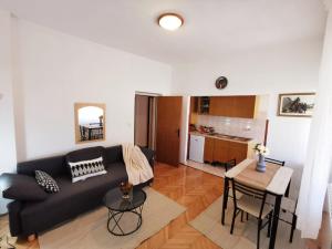 a living room with a black couch and a table at Nice and spacious apartment- Silvio 2 in Banjole