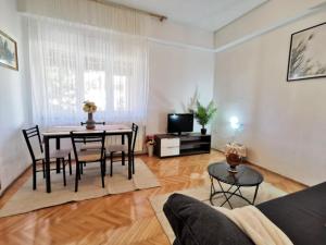 a living room with a table and chairs and a television at Nice and spacious apartment- Silvio 2 in Banjole