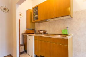 a kitchen with wooden cabinets and a sink at Nice and spacious apartment- Silvio 2 in Banjole +8 photos