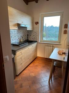 uma pequena cozinha com uma mesa e uma janela em Borghetto Sant’Angelo em Soriano nel Cimino