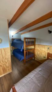 Un dormitorio con una cama con sábanas azules. en Cabañas Flor de Conquil, en Villarrica