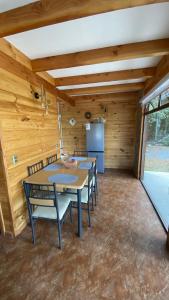 a room with tables and chairs in a room with wooden walls at Cabañas Flor de Conquil in Villarrica