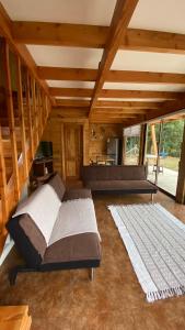 a large bedroom with a bed and a couch at Cabañas Flor de Conquil in Villarrica
