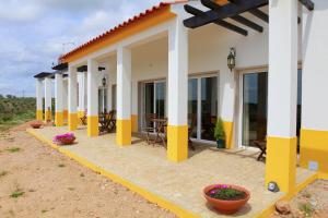 a house with yellow and white columns and windows at Quinta da Caldeireira in Rosmaninhal +25 photos
