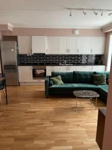 sala de estar con sofá verde y cocina en MyCondo no - Storgt 15b, en Tønsberg