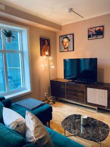 sala de estar con sofá y TV de pantalla plana en MyCondo no - Storgt 15b, en Tønsberg