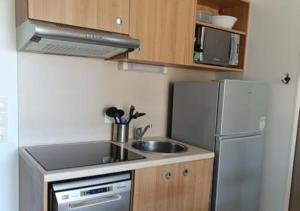 a small kitchen with a sink and a refrigerator at L'argentière, proche plage,Résidence piscine, Tennis, parking in La Londe-les-Maures