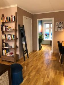 uma sala de estar com piso em madeira e uma estante de livros em MyCondo no - Storgt 15b em Tønsberg