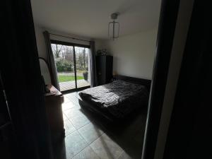 a bedroom with a bed and a sliding glass door at chambre équipée in Panazol