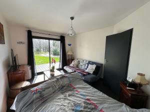 a bedroom with a bed and a couch and a window at chambre équipée in Panazol
