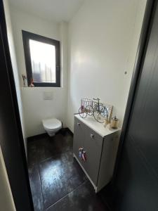 ein kleines Bad mit einem WC und einem Fenster in der Unterkunft chambre équipée in Panazol