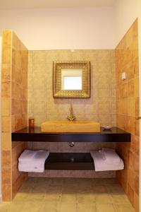 y baño con lavabo, espejo y toallas. en Quinta da Caldeireira, en Rosmaninhal