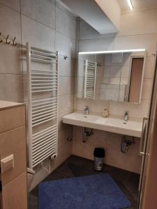 uma casa de banho com 2 lavatórios e um espelho em Sonnleitn AlpinWell Appartment (Ski in&out + Wellness) em Hermagor