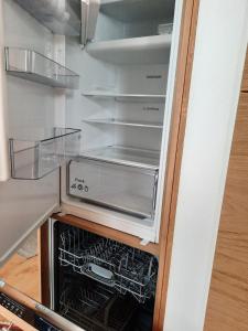 um frigorífico com a sua porta aberta com um forno em Sonnleitn AlpinWell Appartment (Ski in&out + Wellness) em Hermagor