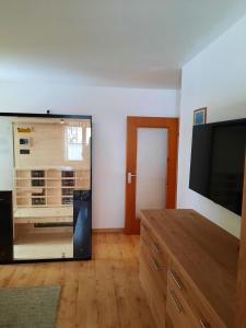 uma sala de estar com uma televisão de ecrã plano e uma cómoda em Sonnleitn AlpinWell Appartment (Ski in&out + Wellness) em Hermagor