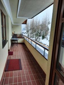 um quarto com uma varanda com vista para a neve em Sonnleitn AlpinWell Appartment (Ski in&out + Wellness) em Hermagor