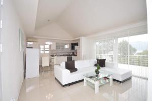 a white living room with a white couch and a table at Вилла Natalia in Krašići