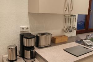 a kitchen counter with two coffee makers on it at City-Appartement Pirna in Pirna +10 photos