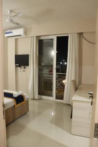 a bedroom with a bed and a window with a balcony at Hotel Shyam Basera in Mathura