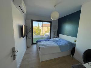 sypialnia z łóżkiem i dużym oknem w obiekcie Maison moderne Avignon 6 pers w Awinionie
