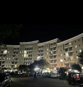 a large apartment building at night with a person riding a bike at Hotel Shyam Basera in Mathura