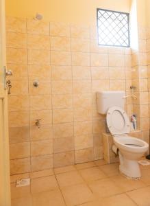 a bathroom with a toilet and a shower at Clarine Cozy Holiday Home in Mtwapa +8 photos