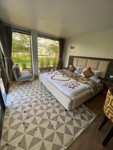 a bedroom with a large bed and a large window at Lake Elementaita Manor in Gilgil