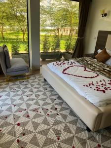 una camera da letto con un letto con petali di rosa sul pavimento di Lake Elementaita Manor a Gilgil