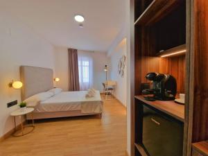 um quarto de hotel com uma cama e uma cozinha em HOSTAL HS CEHEGIN em Cehegín