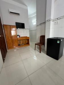 a room with a tv and a chair in a room at Nhà Nghỉ HOA LÝ in Chau Doc