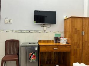 a room with a desk with a tv and a chair at Nhà Nghỉ HOA LÝ in Chau Doc +10 photos