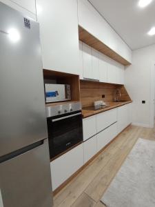 a kitchen with white cabinets and a stainless steel appliance at 2-х комнатная квартира in Semey