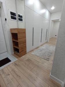 a room with white cabinets and a wooden floor at 2-х комнатная квартира Гоголя 106 in Semey
