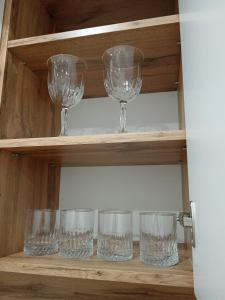 four wine glasses sitting on a shelf at 2-х комнатная квартира in Semey