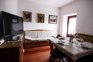 a living room with a table and a bed at Reddish Deer House ::: Cadore Dolomiti in Valle di Cadore