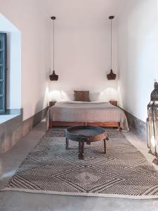 Riad Atay في مراكش: غرفة نوم بسرير وطاولة قهوة