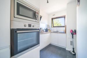 uma cozinha com um micro-ondas por cima de um forno em Bel appartement 2P proche Paris em Fontenay-aux-Roses