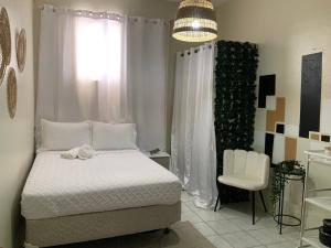um quarto com uma cama e uma cadeira branca em Boricua Guest House Apartment em Yauco