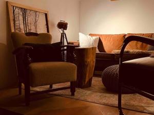 ein Wohnzimmer mit einem Sofa und einem Stuhl in der Unterkunft stilvolles und komfortables Chalet mit Weitblick in Ebenfeld
