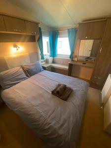 a bedroom with a bed with a towel on it at Orchid meadows retreat in Ashington