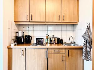 a kitchen with wooden cabinets and a counter top at Gemütliches Seeapartment am Berg in Arrach