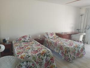 a bedroom with two beds and a desk and a table at Just in paradise in Baie Nettle