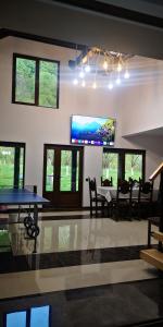 - une salle à manger avec une table de ping-pong et une télévision dans l'établissement Casa de vacanță Edya, à Petroşani