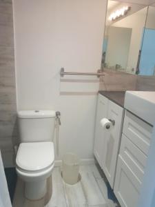 biała łazienka z toaletą i umywalką w obiekcie Just in paradise w mieście Baie Nettle