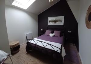 アルジュレス・ガゾストにあるVilla Pyreneの黒のベッドルーム(紫色の枕が付いたベッド付)