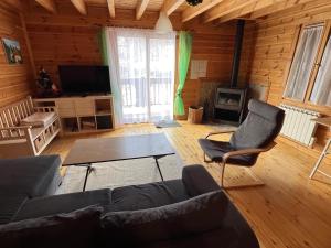 a living room with a couch and chairs and a fireplace at Chalet bois au coeur des Pyrénées ariégeoises in LʼHospitalet-près-lʼAndorre