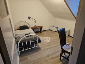 a bedroom with a bed and a table and a chair at Single bed in quiet area in Eindhoven