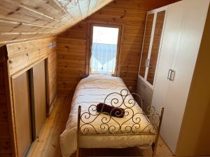 a small bedroom with a bed in a wooden cabin at Chalet bois au coeur des Pyrénées ariégeoises in LʼHospitalet-près-lʼAndorre